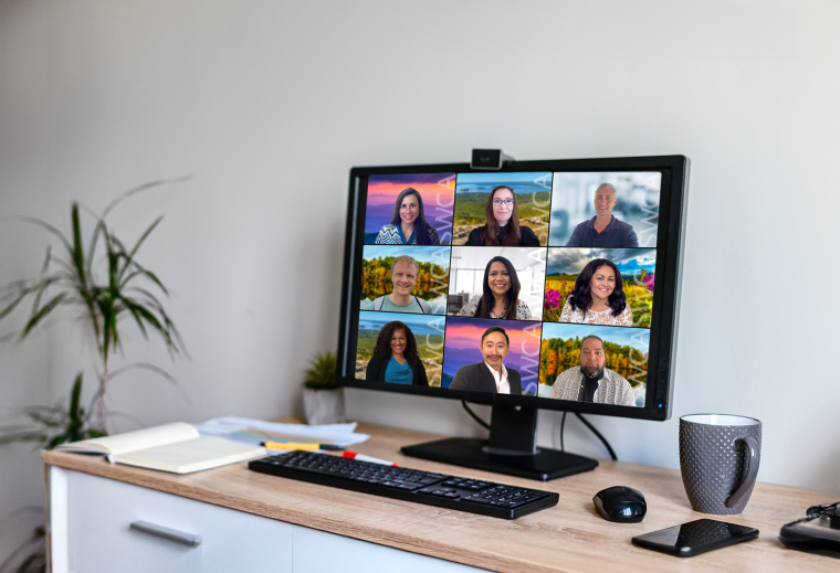 Desk with a monitor screen full of SWCA employees during a zoom meeting. 