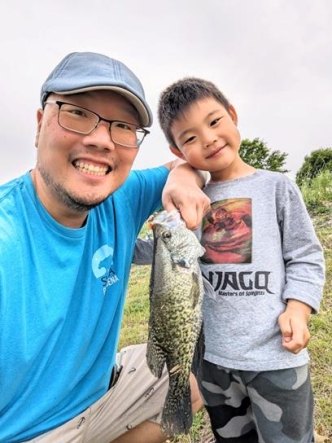 SWCA employee Sunny Lee holding a fish with his son. 