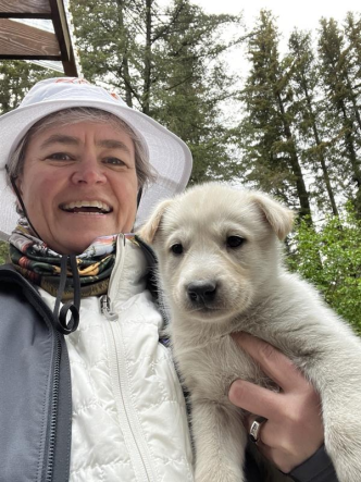 Linda Lannen enjoying time with dogsled puppies in Alaska